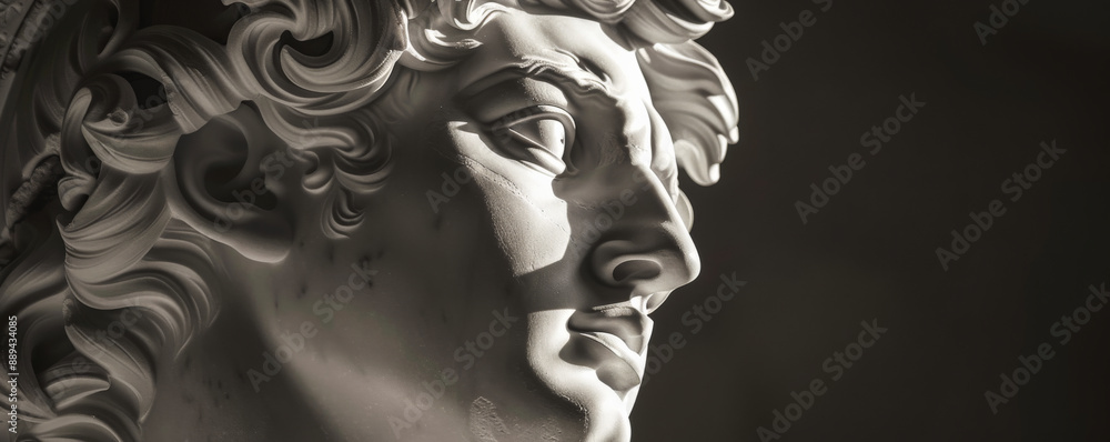 Fototapeta premium Detailed monochrome sculpture of Apollo, the Greek god, highlighting his youthful and serene face, framed by curly hair.