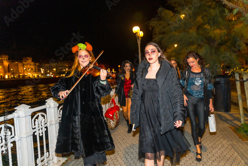 A group of women dressed in black are walking down a street photo