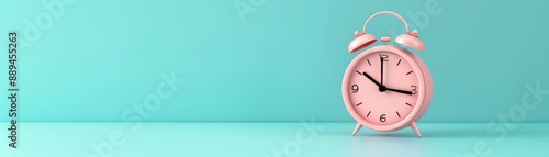 A pink alarm clock with the time of 10:30 on it. The clock is sitting on a blue background photo