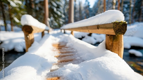 Wallpaper Mural A narrow, snow-laden wooden bridge crosses over a cold, clear stream in a wintry forest, evoking a sense of adventure and the chilly charm of winter's embrace. Torontodigital.ca
