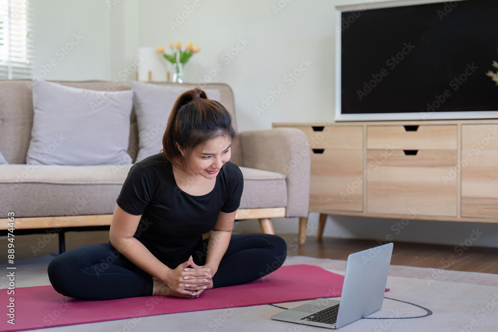 Young Woman Practicing Yoga at Home with Laptop, Smiling and Engaged in Virtual Fitness Class in Cozy Living Room Young Woman Practicing Yoga at Home with Laptop, Smiling and Engaged in Virtual Fitness Class in Cozy Living Room
