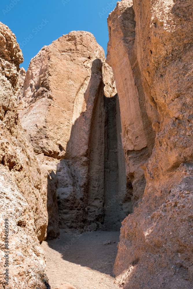 A narrow canyon with a large rock wall on the side A narrow canyon with a large rock wall on the side