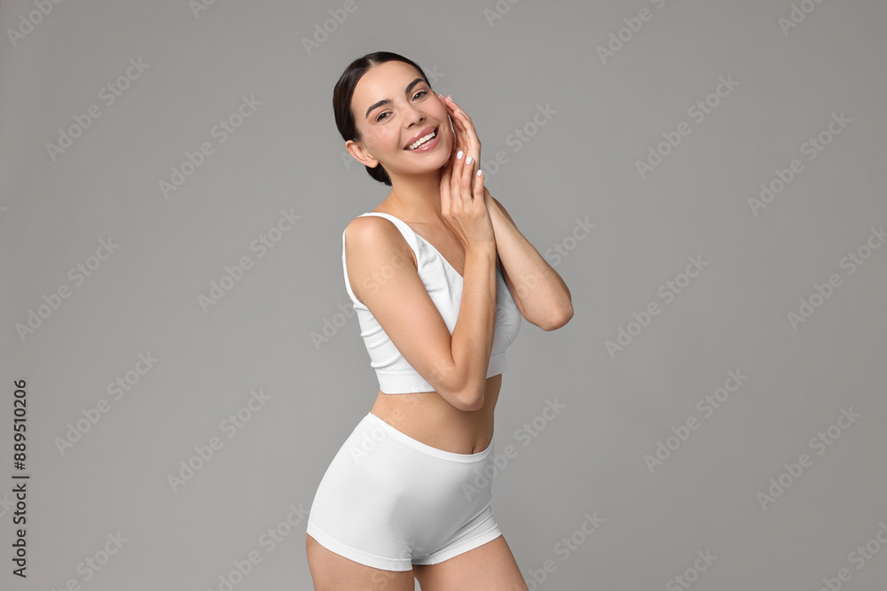 Smiling woman with perfect skin in underwear on grey background. Body care Smiling woman with perfect skin in underwear on grey background. Body care