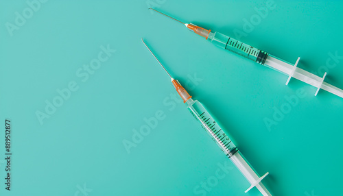 Injection cosmetology. Two medical syringes on turquoise background, top view