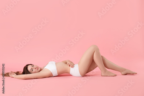 Woman with slim body posing on pink background, space for text