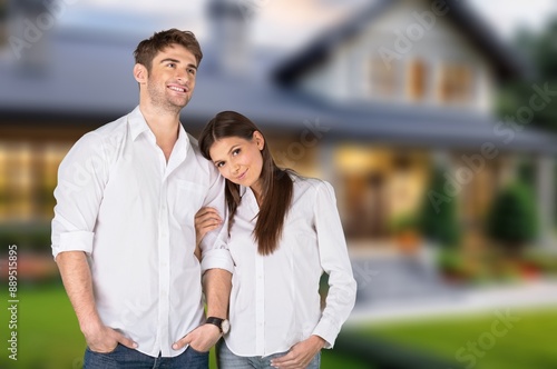 Happy smiling family couple standing outside house