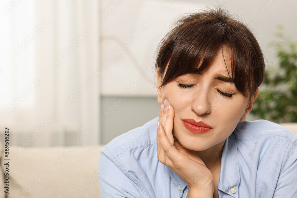 Upset young woman suffering from toothache indoors, space for text Upset young woman suffering from toothache indoors, space for text