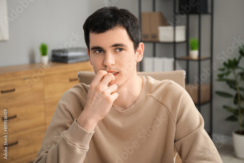 Portrait of embarrassed young man in office photo