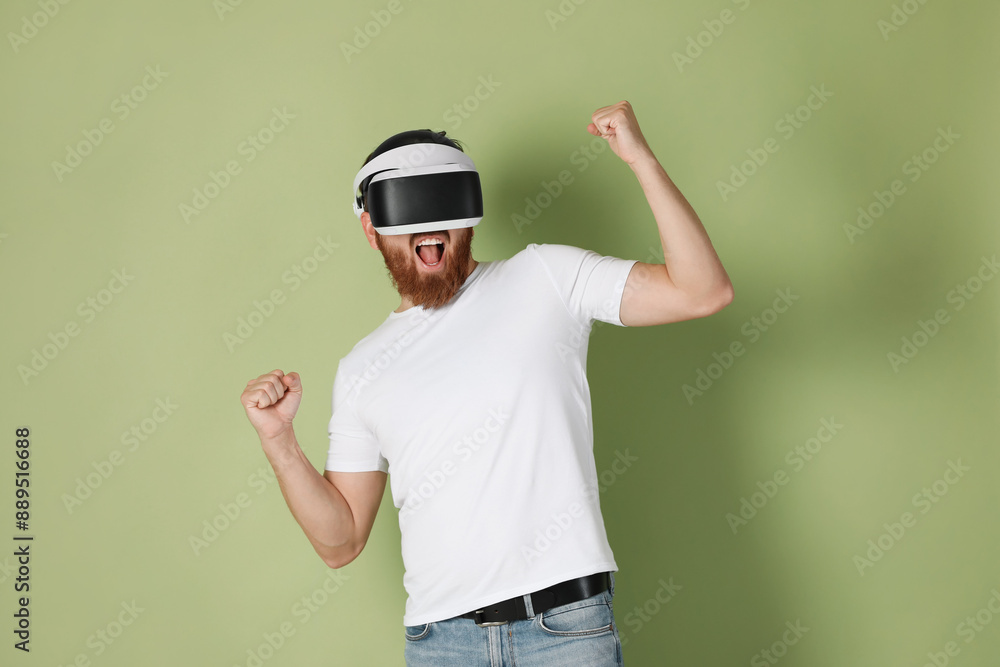 Emotional man using virtual reality headset on pale green background Emotional man using virtual reality headset on pale green background