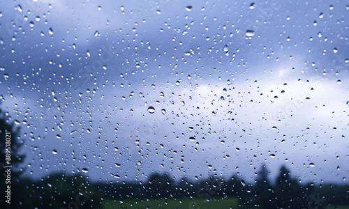Closeup of indoor glass window with rain droplets, and eruptive Lightning Storm in the outside view