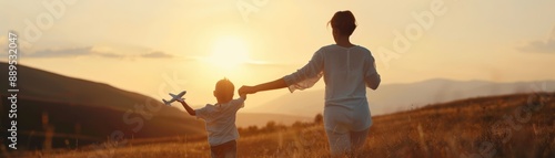 Wallpaper Mural A parent and child enjoy a sunset, running through a field with a toy airplane Torontodigital.ca