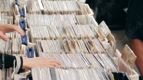 People browsing vinyl records in a music store, surrounded by retro albums in physical format photo