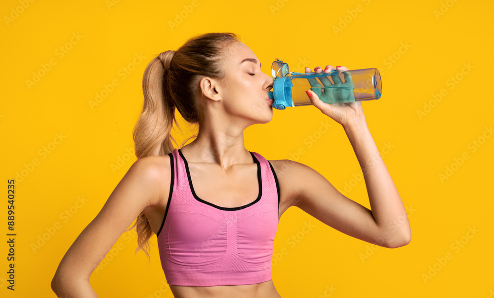 Hydration Concept. Fit Girl Drinking Water During Workout Training On Pink Background. Studio Shot Hydration Concept. Fit Girl Drinking Water During Workout Training On Pink Background. Studio Shot