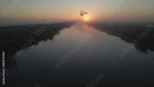 Aerial view of serene countryside with windmill, fog, and meadow, Lytsewierrum, Friesland, Netherlands. photo