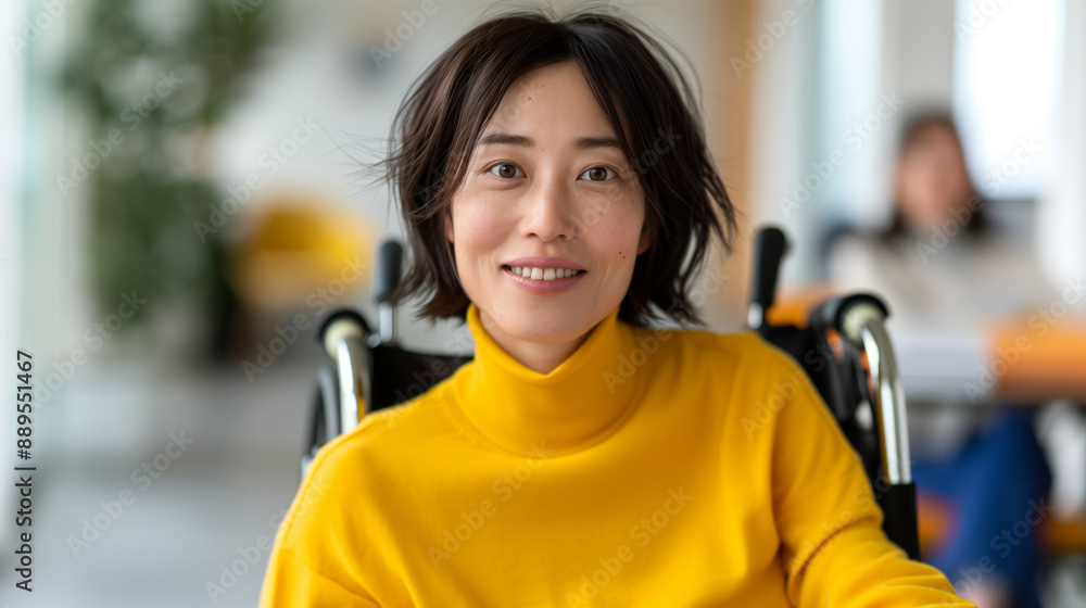Japanese woman smiling in yellow sweater sitting in a wheelchair office setting Japanese woman smiling in yellow sweater sitting in a wheelchair office setting