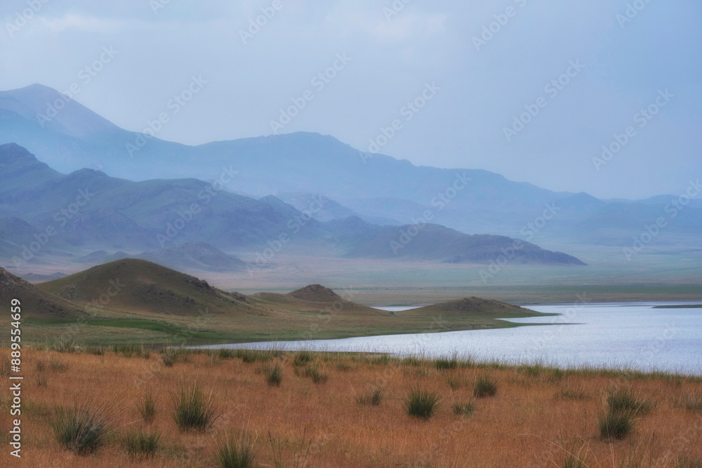 Beautiful Salt Lake Tuzkol in Kazakhstan and its steppe shores and mountains in the gradient haze of an autumn morning.