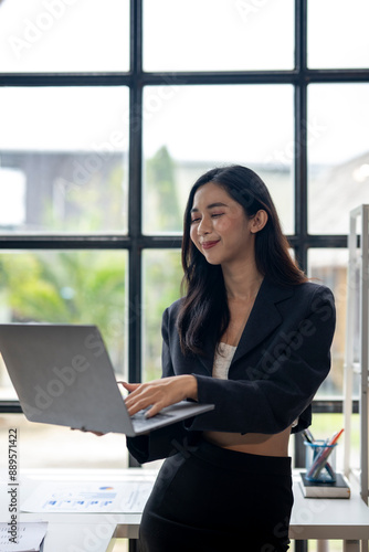 A woman is sitting at a desk with a laptop in front of her Free Download A woman is sitting at a desk with a laptop in front of her - GFXLoad
