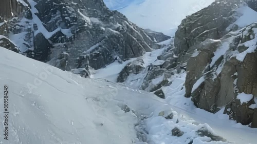 Zooming in on a tiny stream forming from a melting pile of snow on the side of a mountain highlighting the delicate yet powerful force of spring thaw. photo