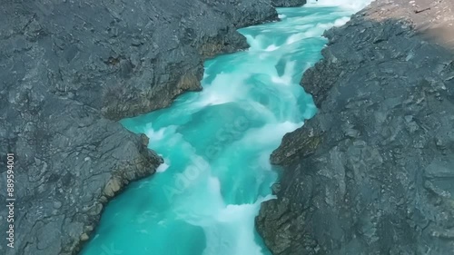 The vibrant blue waters of the glacial meler streams contrast against the grey landscape creating a stunning visual display. photo