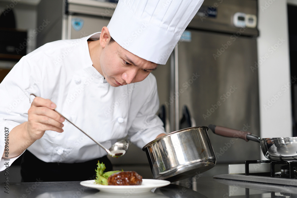 料理を皿に盛る若いアジア人の男性調理師 料理を皿に盛る若いアジア人の男性調理師