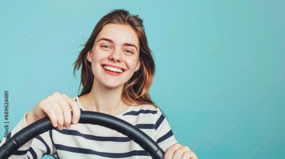 portrait of a woman holding a steering wheel in front of blue background portrait of a woman holding a steering wheel in front of blue background