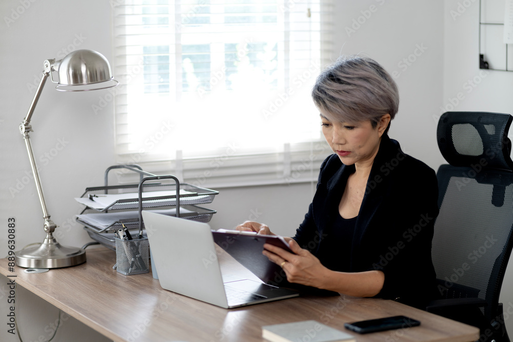 senior businesswoman is sitting and typing information senior businesswoman is sitting and typing information