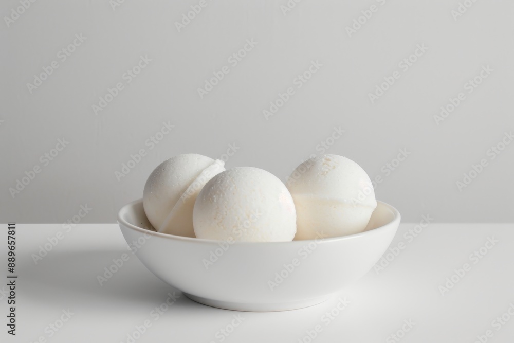 A beautiful arrangement of natural bath bombs on a white ceramic dish, perfect for a relaxing bath experience. The white background adds a touch of elegance to the overall scene. A beautiful arrangement of natural bath bombs on a white ceramic dish, perfect for a relaxing bath experience. The white background adds a touch of elegance to the overall scene.