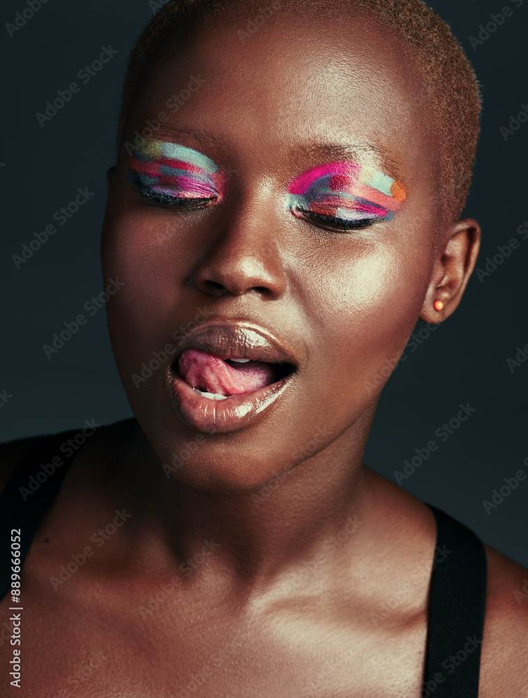 Black woman, tongue and relax in studio for makeup, beauty and cosmetics for self care. Model girl, calm or peace and mouth or eyeshadow for art deco, aesthetics and glow for shine by dark background Black woman, tongue and relax in studio for makeup, beauty and cosmetics for self care. Model girl, calm or peace and mouth or eyeshadow for art deco, aesthetics and glow for shine by dark background