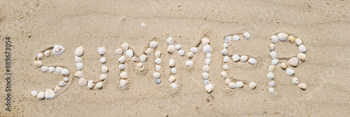 Summer beach concept with the word 'SUMMER' spelled out using seashells on sandy beach, ideal for vacation and relaxation themes