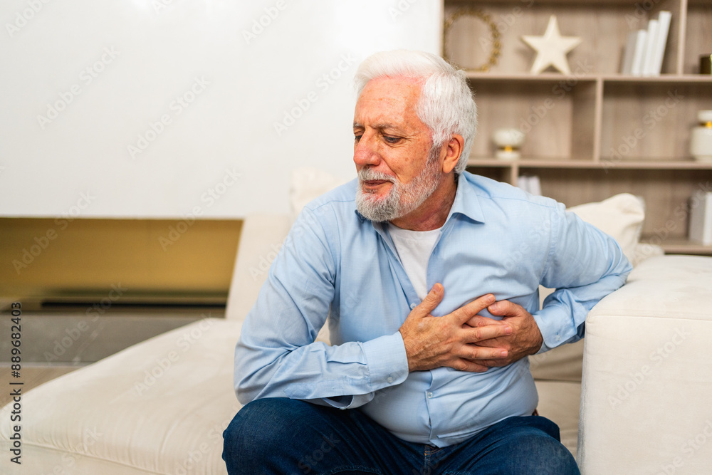 Pain on heart, heart attack. Unhappy middle aged senior man suffering from chest pain heart attack problems with health at home. Mature old senior grandfather touching chest experiencing infarction Pain on heart, heart attack. Unhappy middle aged senior man suffering from chest pain heart attack problems with health at home. Mature old senior grandfather touching chest experiencing infarction