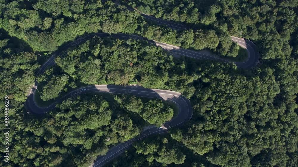 Aerial view of the road passing through the mountain and green forest. Curve asphalt road on mountain. Aerial view of the road passing through the mountain and green forest. Curve asphalt road on mountain.