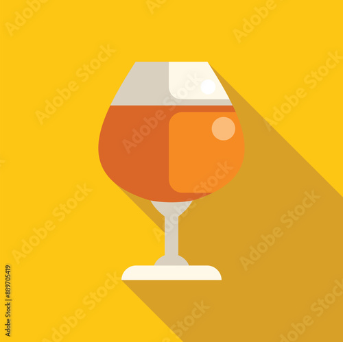 Glass of cognac is standing on a yellow background with a long shadow