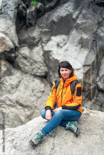 A young girl tourist poses against the backdrop of a picturesque mountain gorge. North Caucasus. Russia