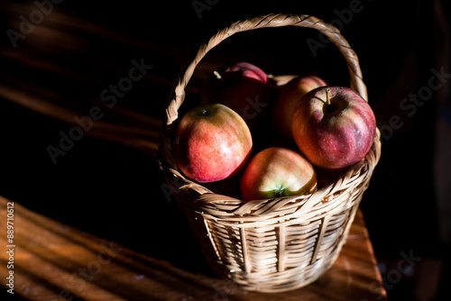 Basket Of Fresh Red Apples On Wooden Surface photo