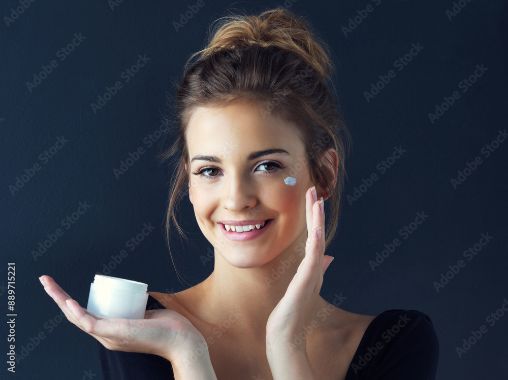 Happy woman, portrait and cream with skincare for beauty or moisturizer on a blue studio background. Young female person or model with smile or container for anti aging lotion, spf or skin hydration Happy woman, portrait and cream with skincare for beauty or moisturizer on a blue studio background. Young female person or model with smile or container for anti aging lotion, spf or skin hydration