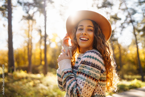 Portrait of attractive stylish woman walking in autumn park. Concept of vacation, travel, nature, freedom.