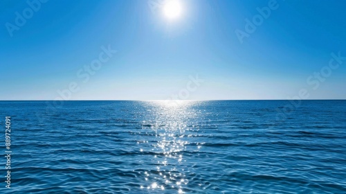 Serene Ocean Horizon Under Clear Blue Sky with Glistening Sun Reflection