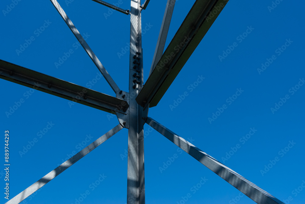 Bolted connections of steel elements of the observation tower. Construction details of galvanized steel against a blue sky background.