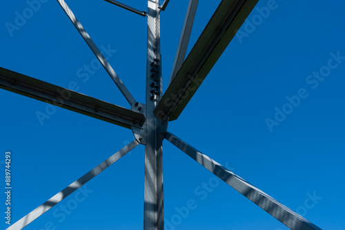 Obraz na płótnie Bolted connections of steel elements of the observation tower. Construction details of galvanized steel against a blue sky background. w salonie