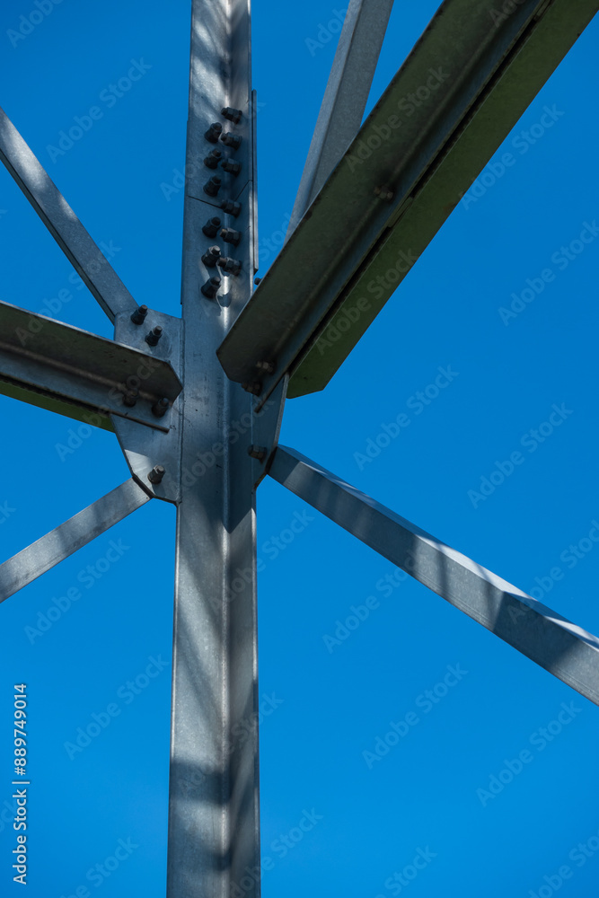 Bolted connections of steel elements of the observation tower. Construction details of galvanized steel against a blue sky background.