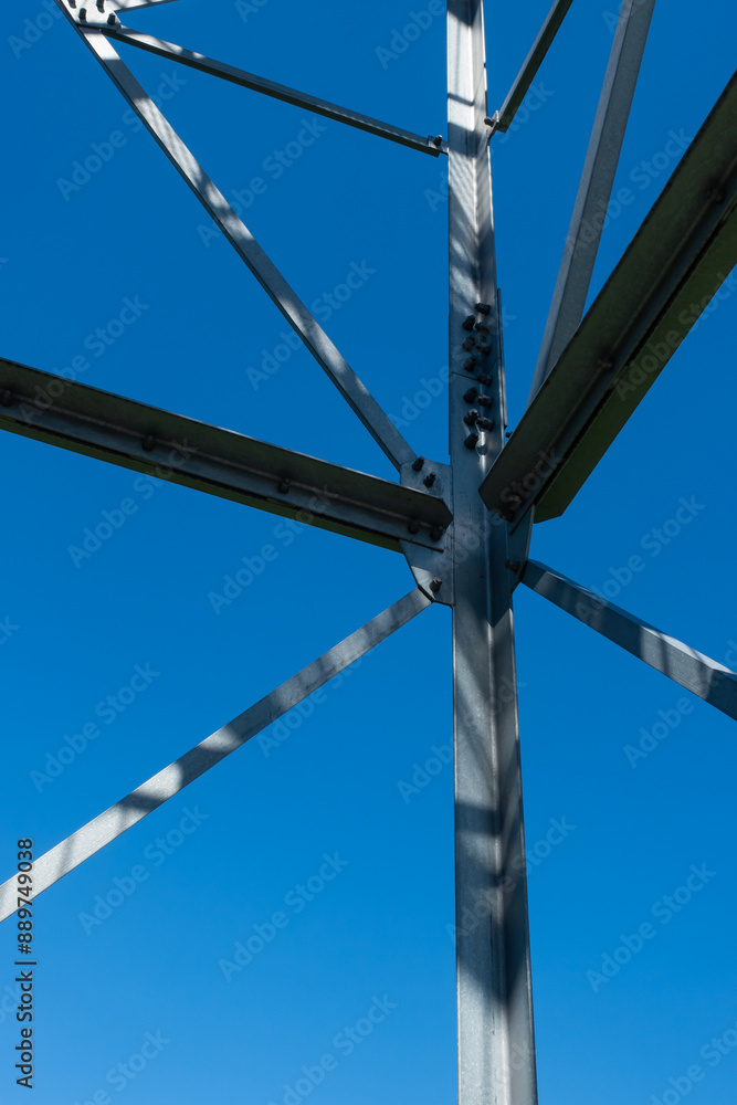 Bolted connections of steel elements of the observation tower. Construction details of galvanized steel against a blue sky background.