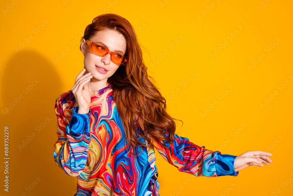 Photo of gorgeous girl with foxy hairstyle dressed print shirt in sunglass look at offer empty space isolated on yellow color background Photo of gorgeous girl with foxy hairstyle dressed print shirt in sunglass look at offer empty space isolated on yellow color background