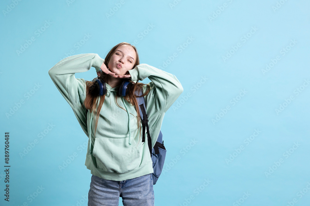 Playful young girl blowing kisses to camera, being flirty. Lively charming teenage person having fun sending air kisses, doing romantic gesturing, isolated over studio background Playful young girl blowing kisses to camera, being flirty. Lively charming teenage person having fun sending air kisses, doing romantic gesturing, isolated over studio background