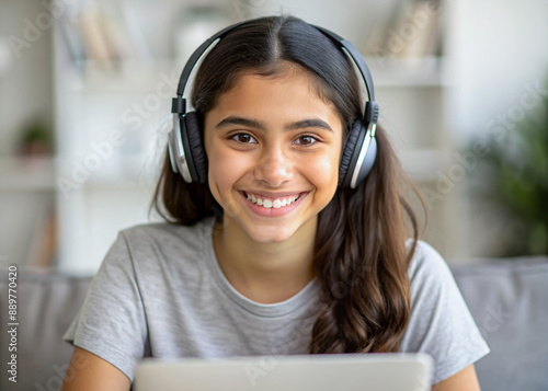 Smiling hispanic teen girl school student wear headphones looking at webcam distance learning. Zoom video call remote class, online lessons and courses concept. Headshot portrait. Webcamera view.