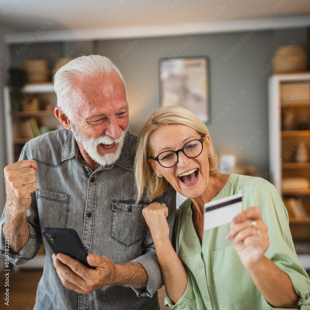 Senior couple buy online whit credit card on mobile phone at home