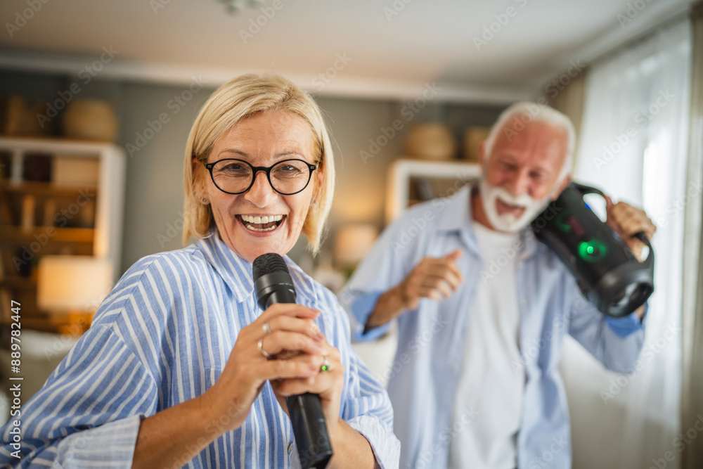 Mature wife sing on microphone with senior husband with loudspeaker Mature wife sing on microphone with senior husband with loudspeaker