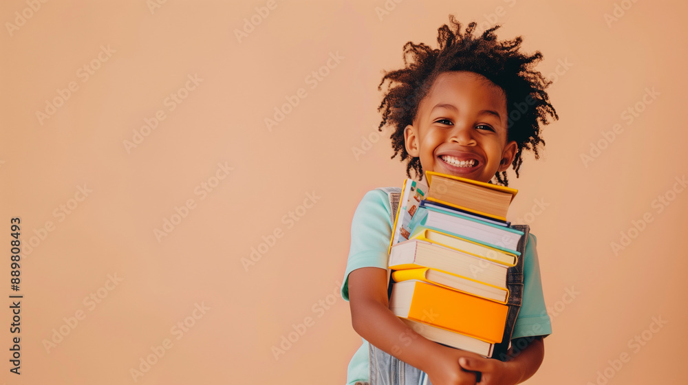 Happy Young Boy Holding Books In Front Of A Peach Wall Happy Young Boy Holding Books In Front Of A Peach Wall