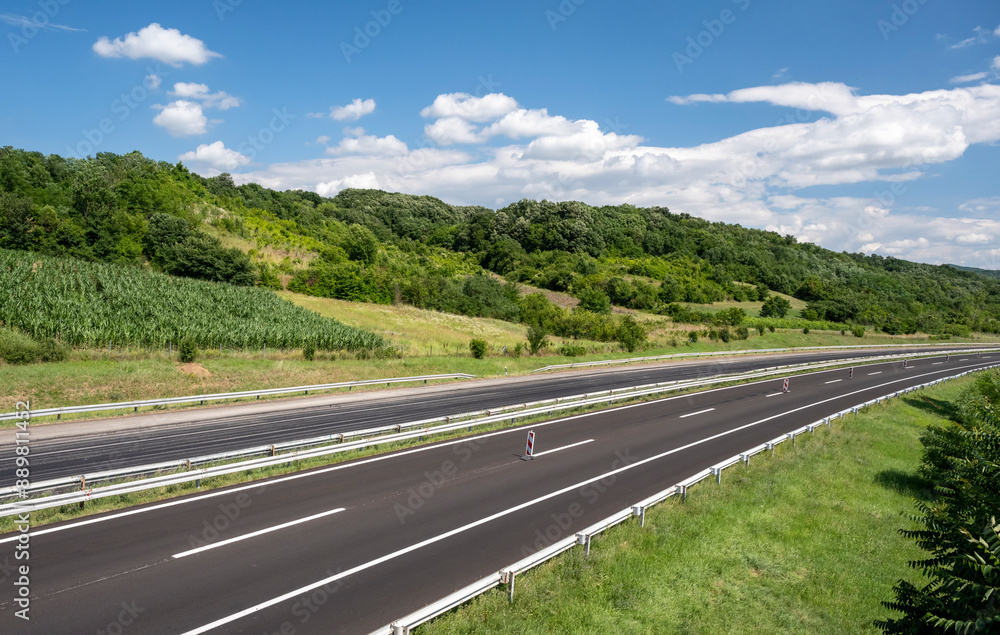 Fototapeta premium Empty open highway through pastoral landscape