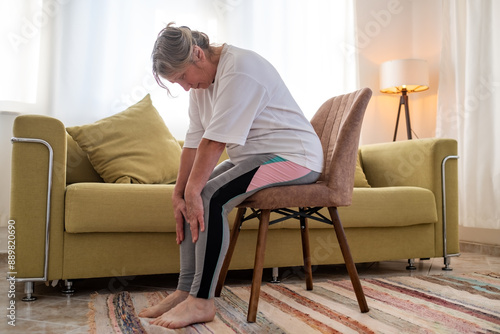 Senior caucasian woman doing doing yoga at home on sofa