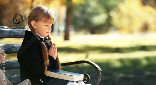 Little girl with Bible pray...
